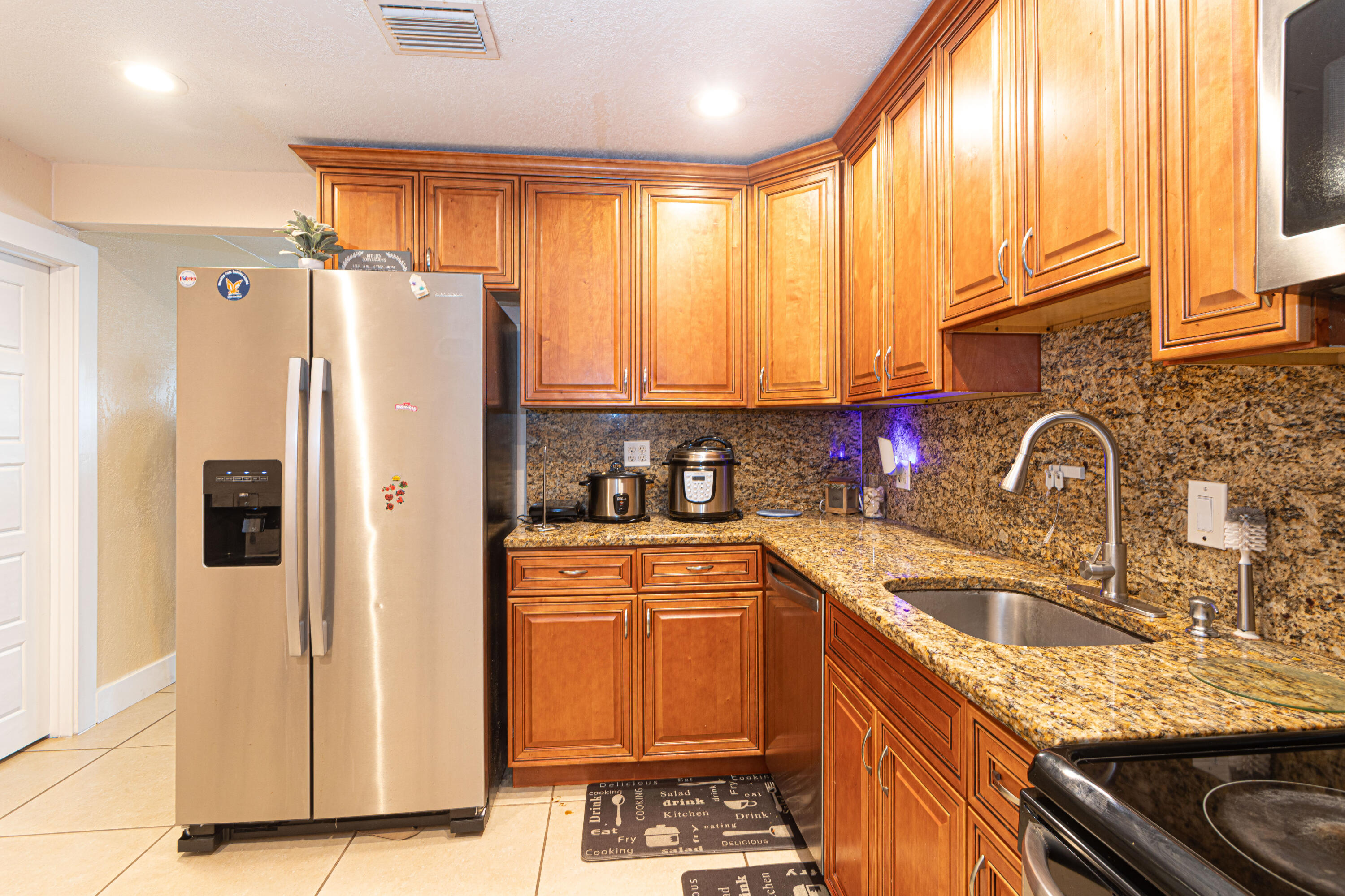 740 Aspen Road West Palm Beach, FL 33409 - Photo 15 of 34 a kitchen with stainless steel appliances granite countertop a refrigerator sink and cabinets