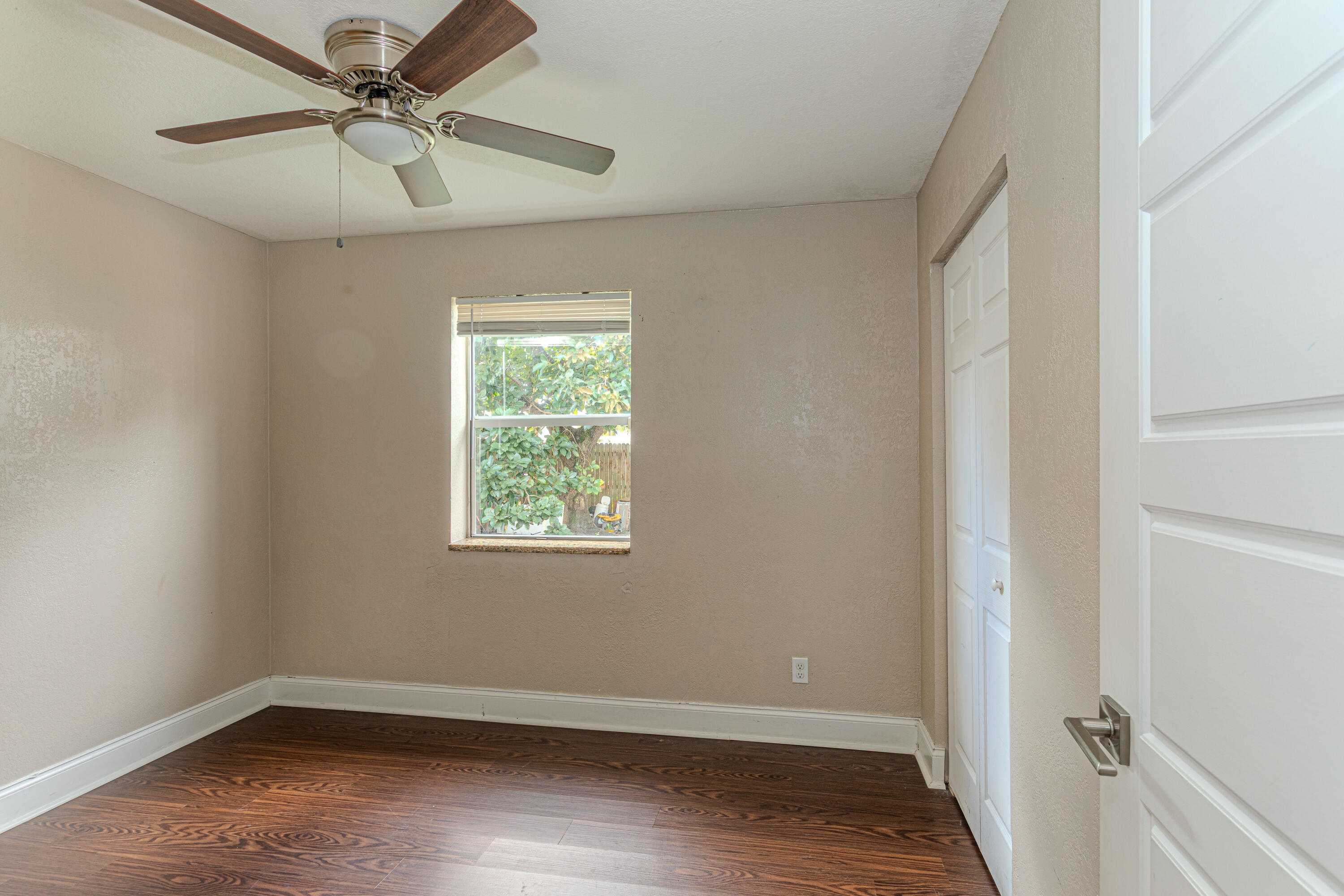 740 Aspen Road West Palm Beach, FL 33409 - Photo 16 of 34 a view of an empty room with a window and wooden floor