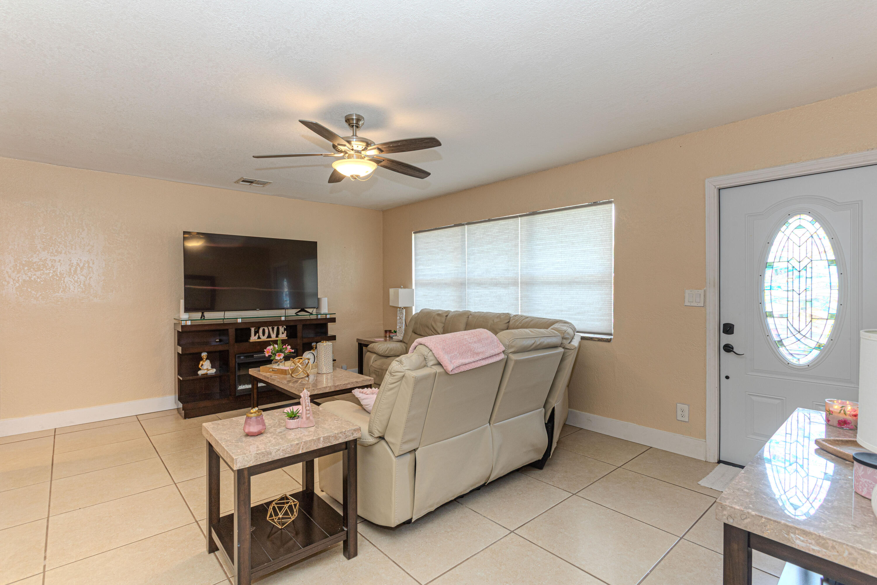 740 Aspen Road West Palm Beach, FL 33409 - Photo 9 of 34 a living room with furniture a flat screen tv and a window