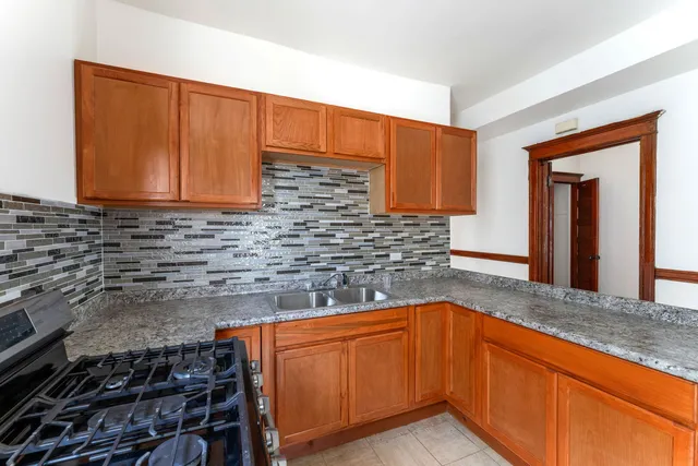 a kitchen with granite countertop cabinets stove and sink