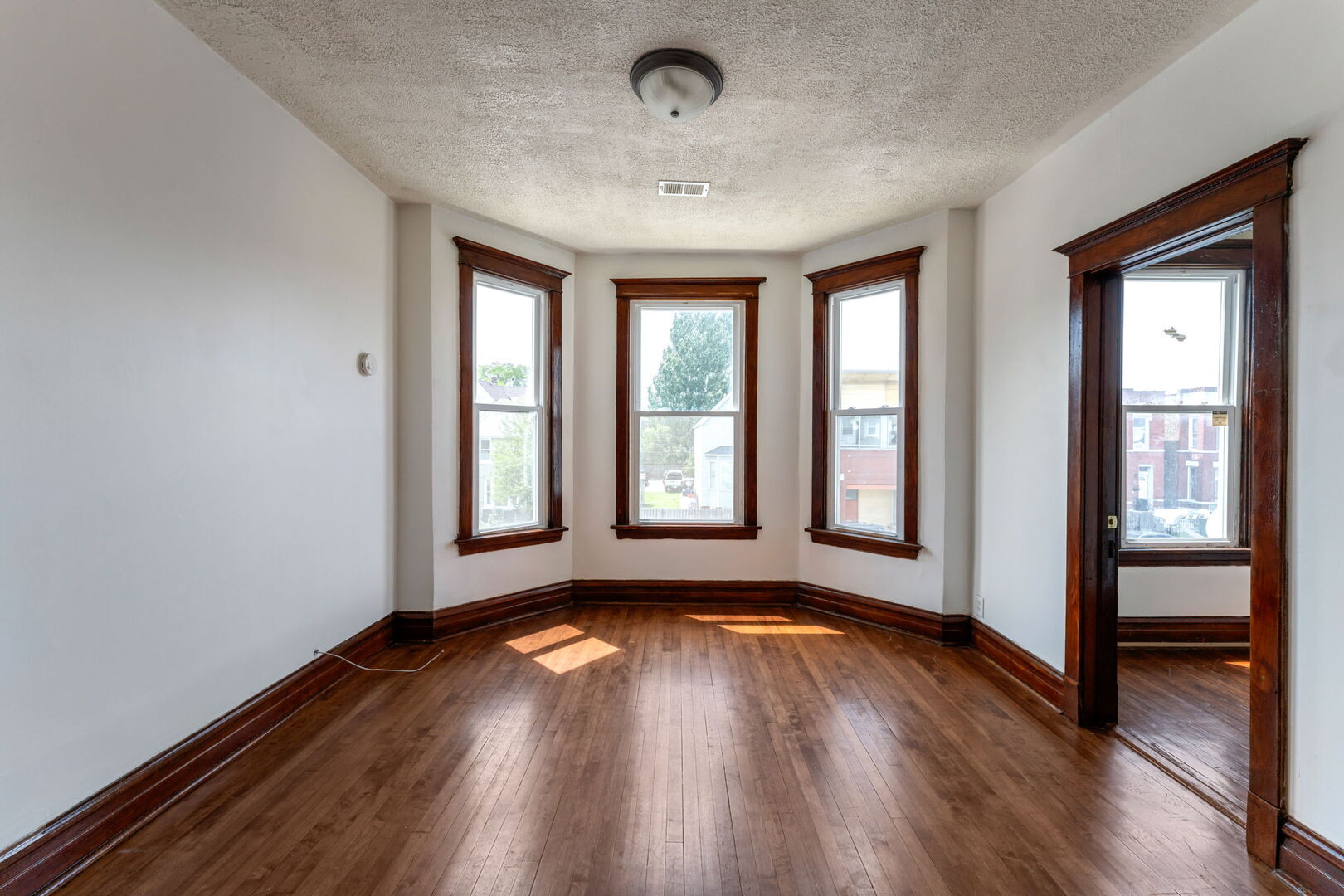 1921 North Pulaski Road, Unit 2 Chicago, IL 60639 - Photo 2 of 15 a view of an empty room with wooden floor and a window