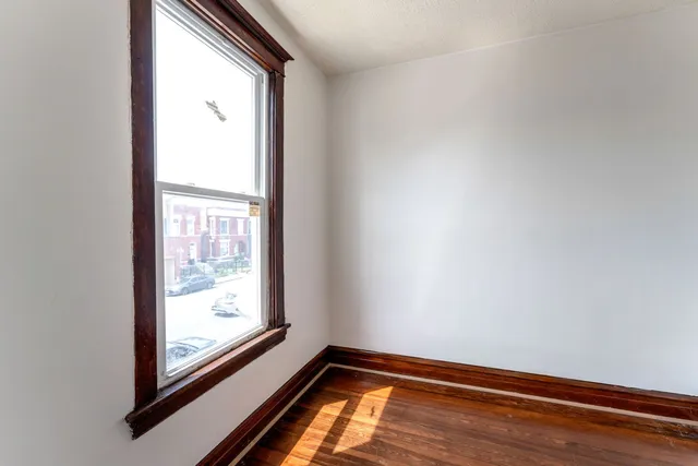 a view of a room with wooden floor and windows