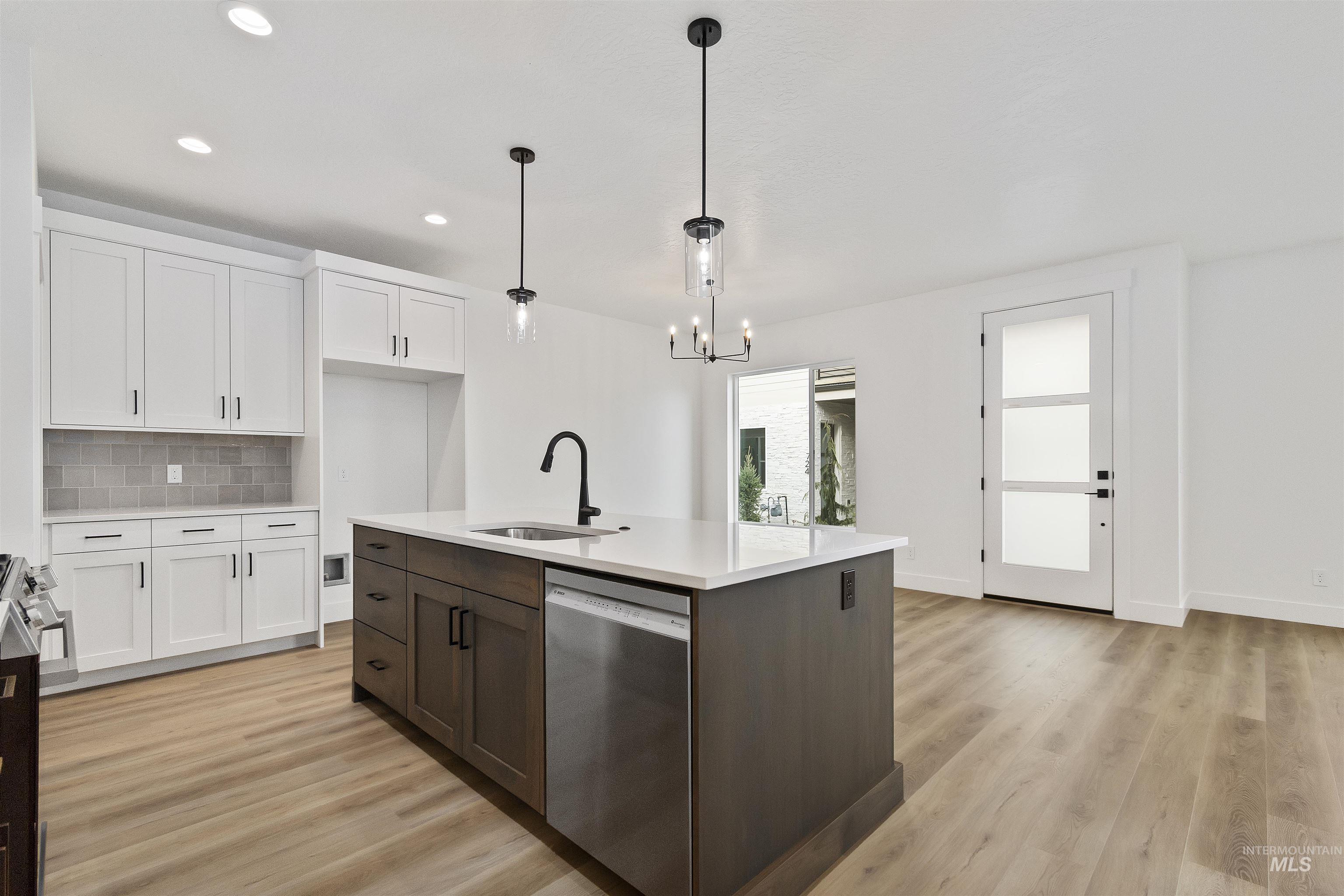 764 South Calhoun Lane Star, ID 83669 - Photo 11 of 48 Kitchen featuring white cabinets, stainless steel appliances, tasteful backsplash, pendant lighting, and light wood-style floors