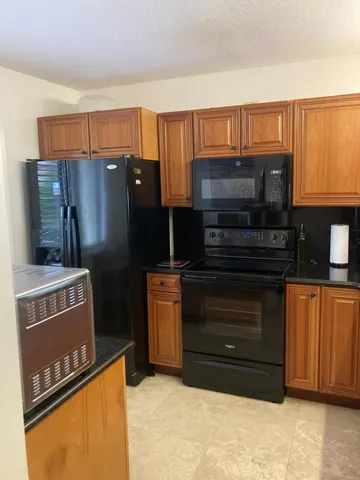 a kitchen with stainless steel appliances granite countertop a refrigerator and a stove