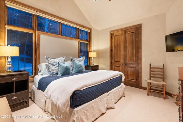 a bedroom with bed tv and window