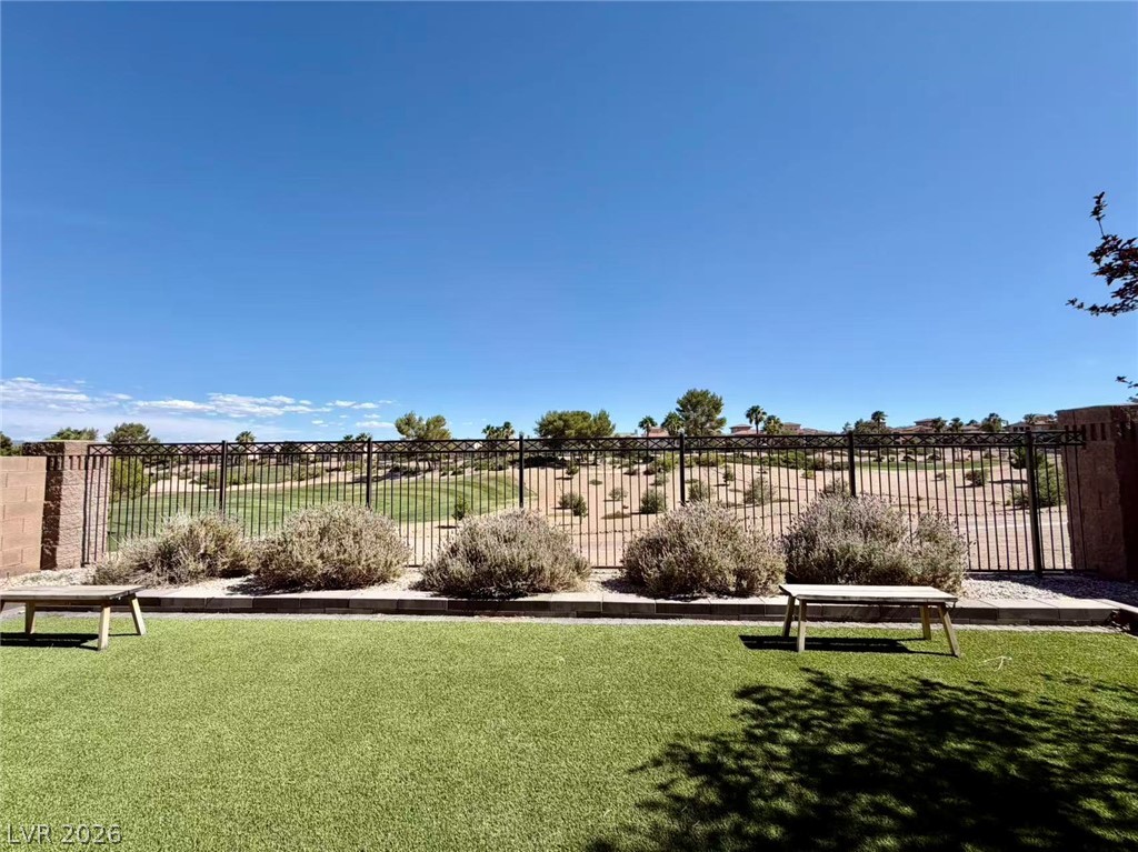 135 Tall Ruff Drive Las Vegas, NV 89148 - Photo 27 of 29 Green turf and desert landscaping blend seamlessly, creating a serene outdoor escape.