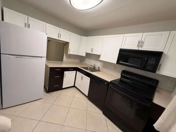 a kitchen with a refrigerator a stove a microwave and sink