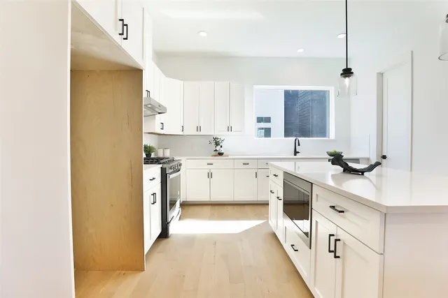 a kitchen with cabinets stainless steel appliances and a sink