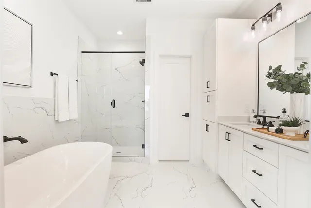 a bathroom with a tub sink a mirror and shower