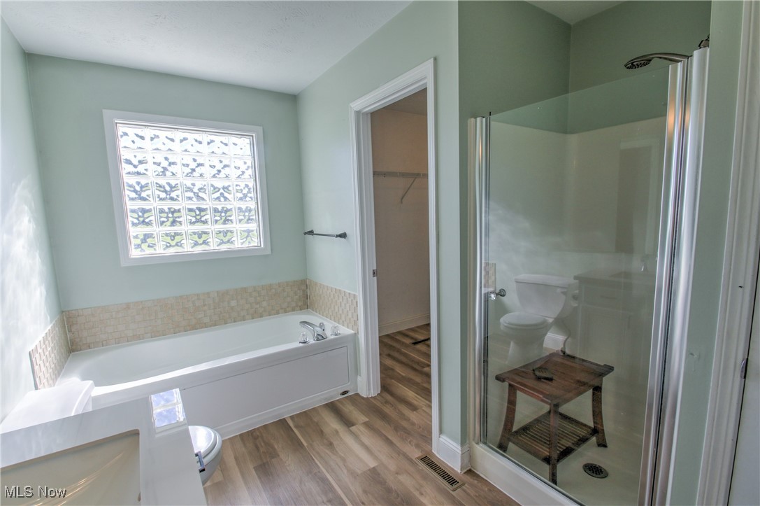 4998 Wayne Road Mantua, OH 44255 - Photo 22 of 43 Master Bathroom with hardwood / wood-style floors, toilet, and shower with separate bathtub