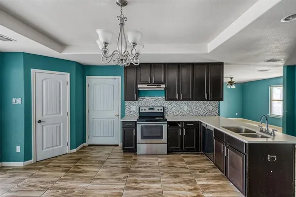 a large kitchen with stainless steel appliances granite countertop a stove and a sink