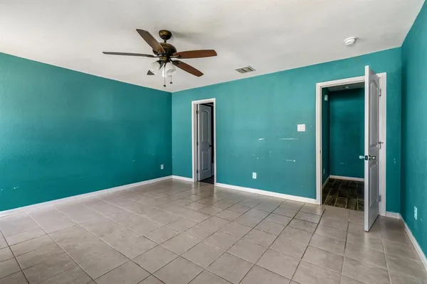 an empty room with closet and a chandelier fan