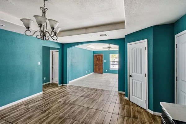 a view of a hallway with wooden floor and chandelier