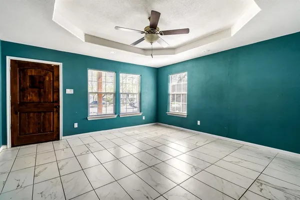 a view of an empty room with window and cabinet