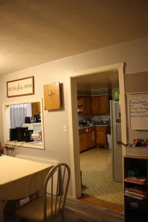 a living room with a baby crib furniture and a chandelier