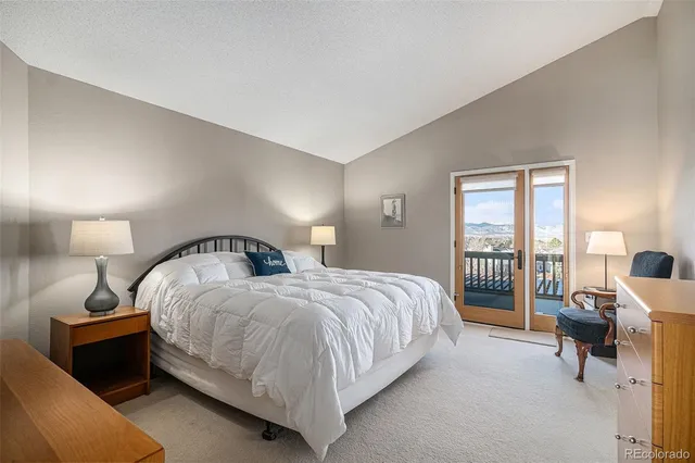 a bedroom with a bed and large windows