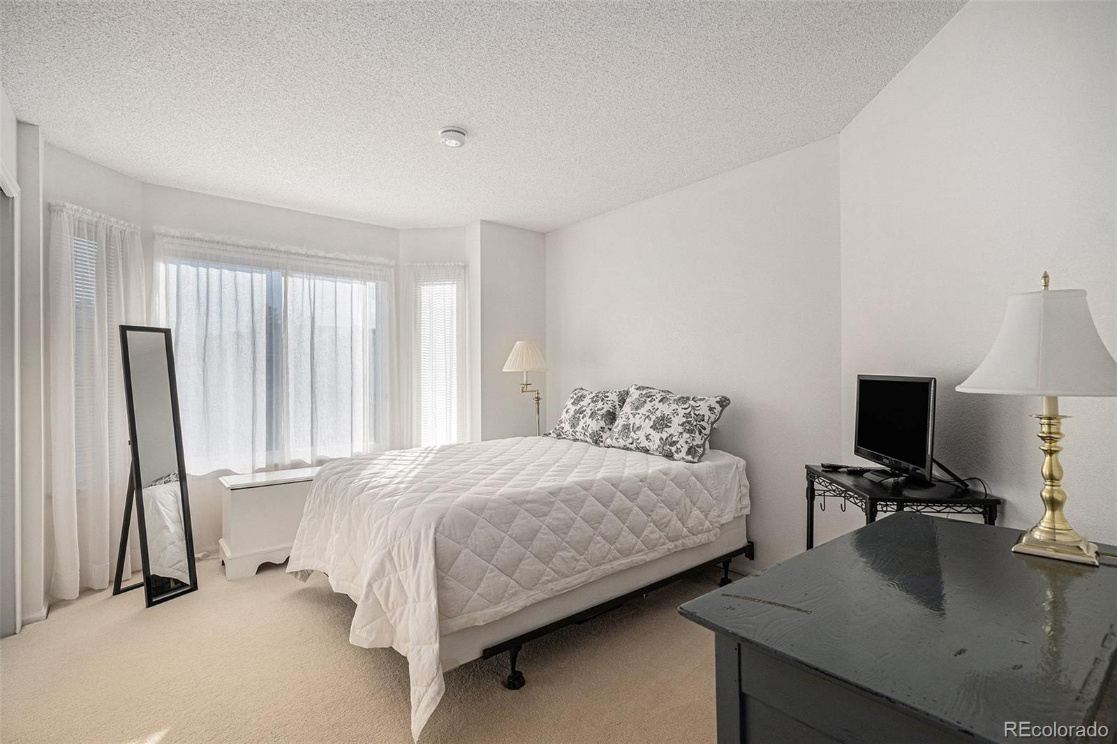 9537 Chesapeake Street Highlands Ranch, CO 80126 - Photo 20 of 34 a bedroom with a bed and a flat screen tv