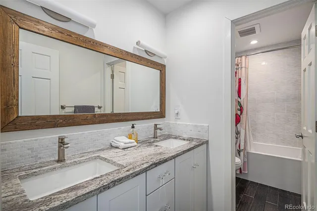 a bathroom with a granite countertop sink and a mirror
