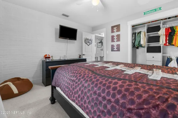 a bedroom with a bed and flat screen tv