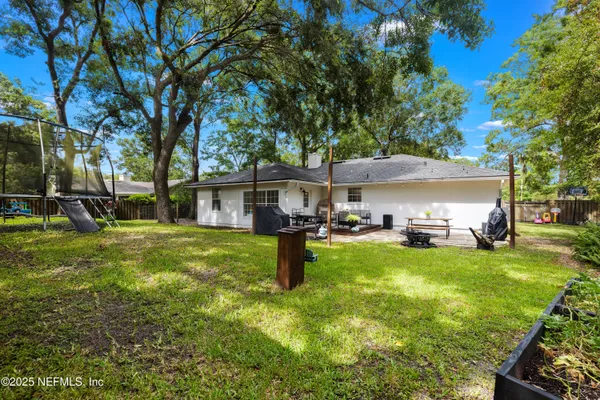a view of a house with backyard and sitting area