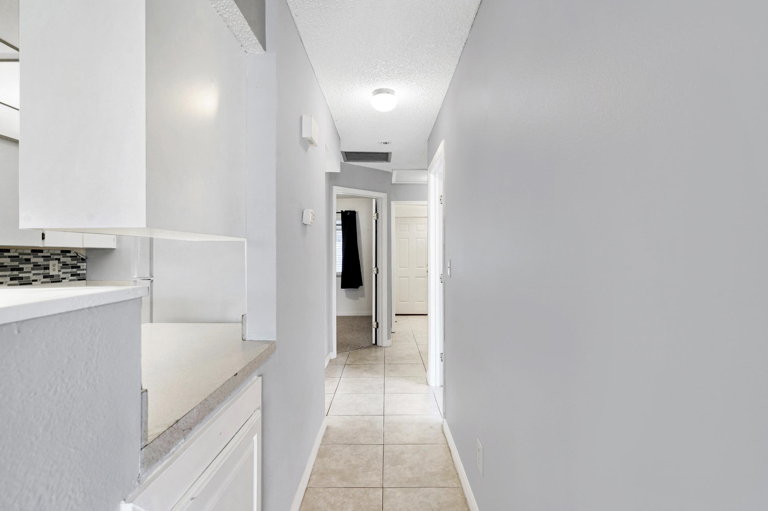 127 Rio Del Mar Street, Unit C St. Augustine, FL 32080 - Photo 13 of 29 Corridor featuring light tile patterned floors and a textured ceiling
