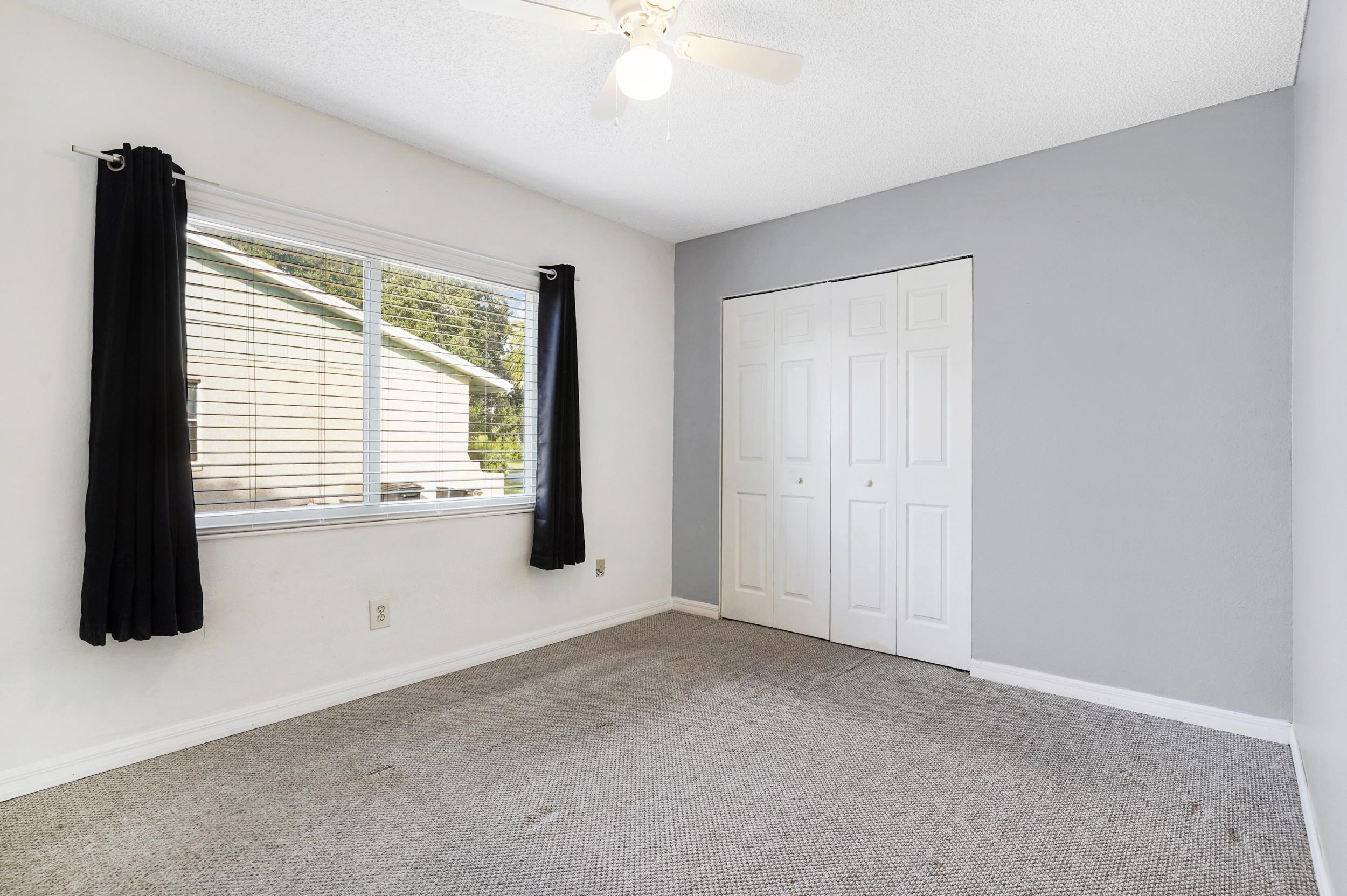 127 Rio Del Mar Street, Unit C St. Augustine, FL 32080 - Photo 15 of 29 Unfurnished bedroom featuring a closet, carpet, a textured ceiling, and a ceiling fan