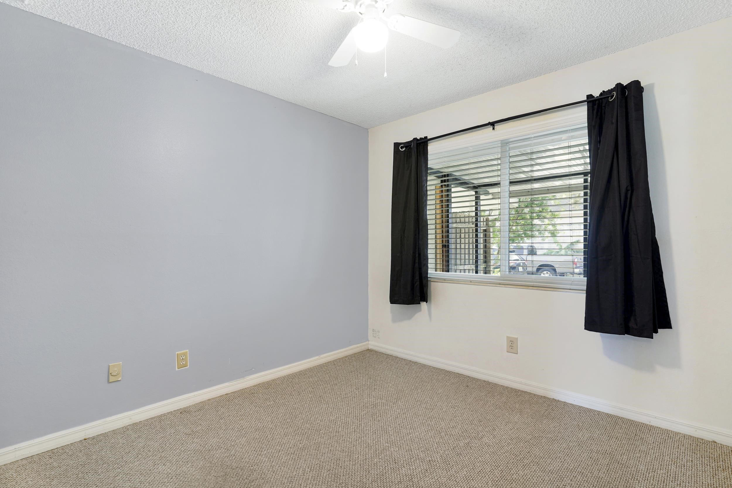 127 Rio Del Mar Street, Unit C St. Augustine, FL 32080 - Photo 18 of 29 Empty room with a textured ceiling, carpet floors, and ceiling fan