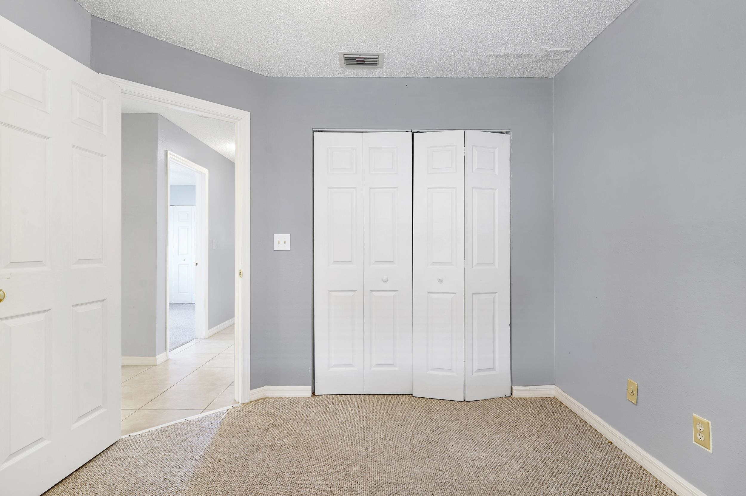 127 Rio Del Mar Street, Unit C St. Augustine, FL 32080 - Photo 19 of 29 Unfurnished bedroom featuring light carpet, a closet, and a textured ceiling