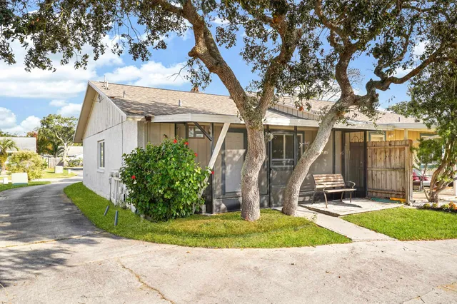 a view of a house with backyard and a tree