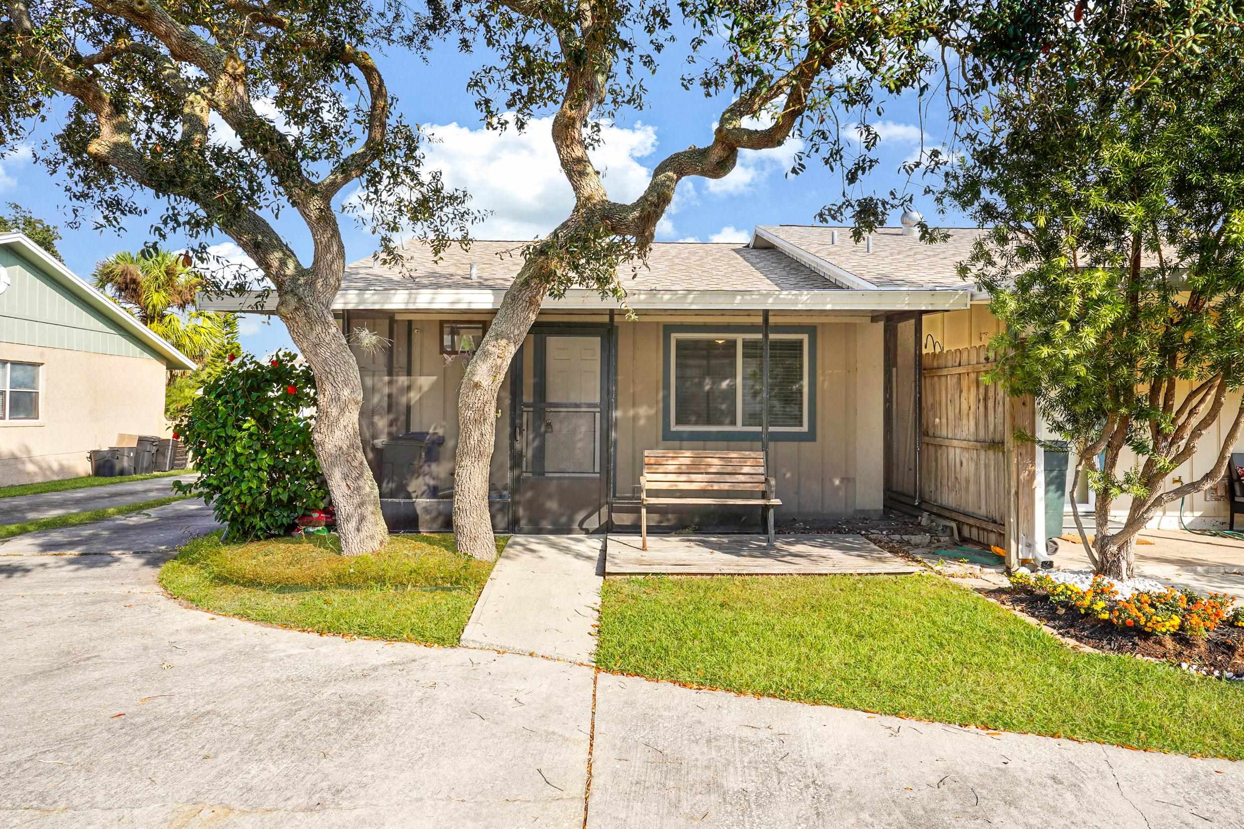 127 Rio Del Mar Street, Unit C St. Augustine, FL 32080 - Photo 4 of 29 View of front of house featuring roof with shingles, a front yard, and a sunroom