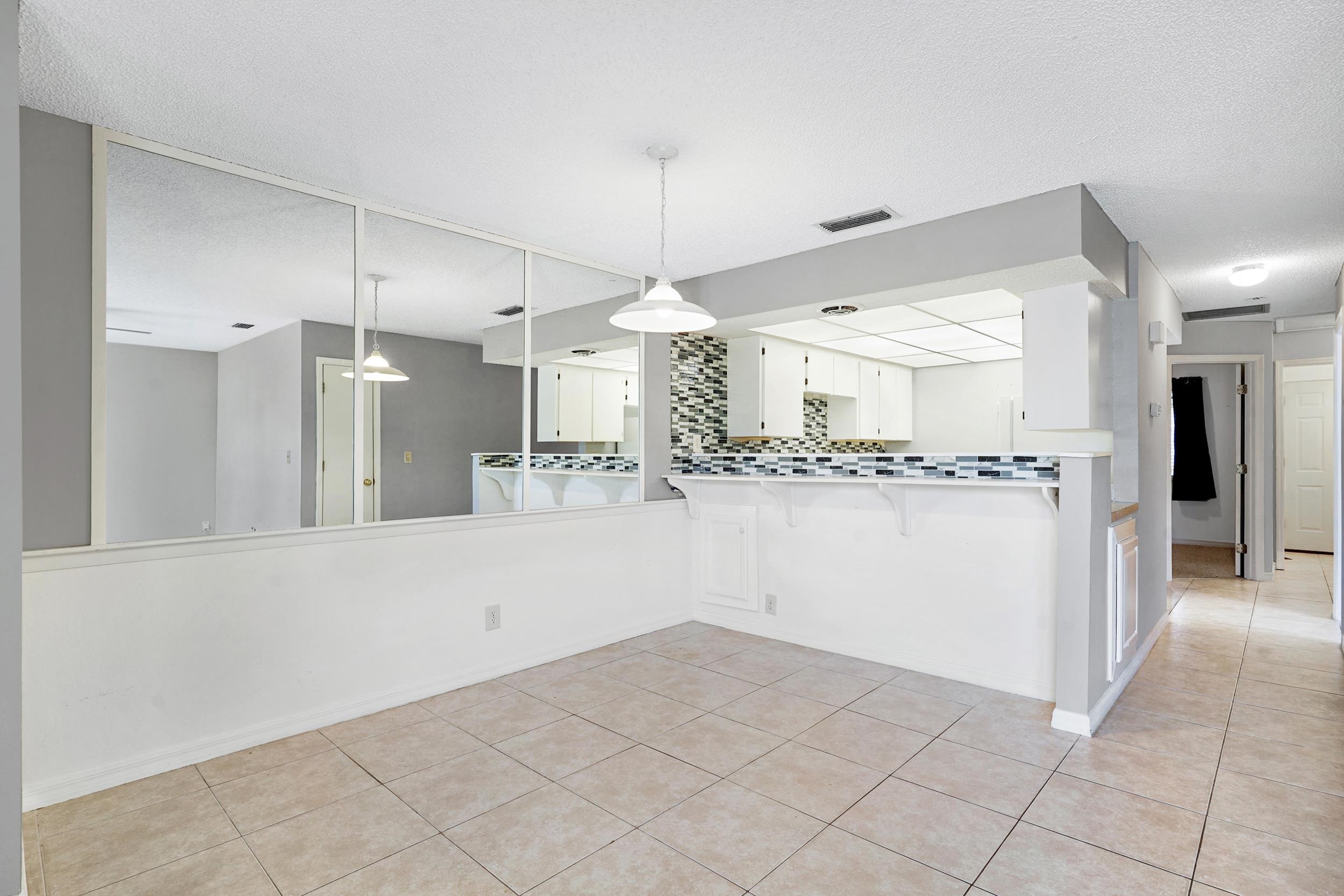 127 Rio Del Mar Street, Unit C St. Augustine, FL 32080 - Photo 6 of 29 Kitchen with tasteful backsplash, a breakfast bar, hanging light fixtures, white cabinetry, and light countertops