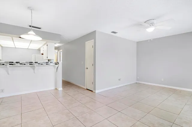 a view of a kitchen with a sink and dishwasher a refrigerator with white cabinets