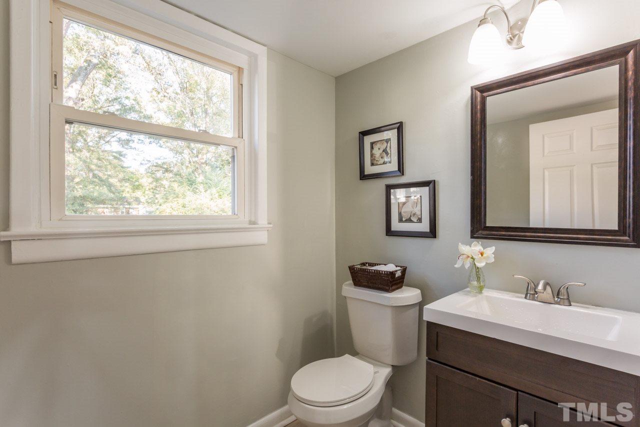 1012 Weston Street Raleigh, NC 27610 - Photo 18 of 23 a bathroom with a granite countertop toilet a sink a mirror and a window