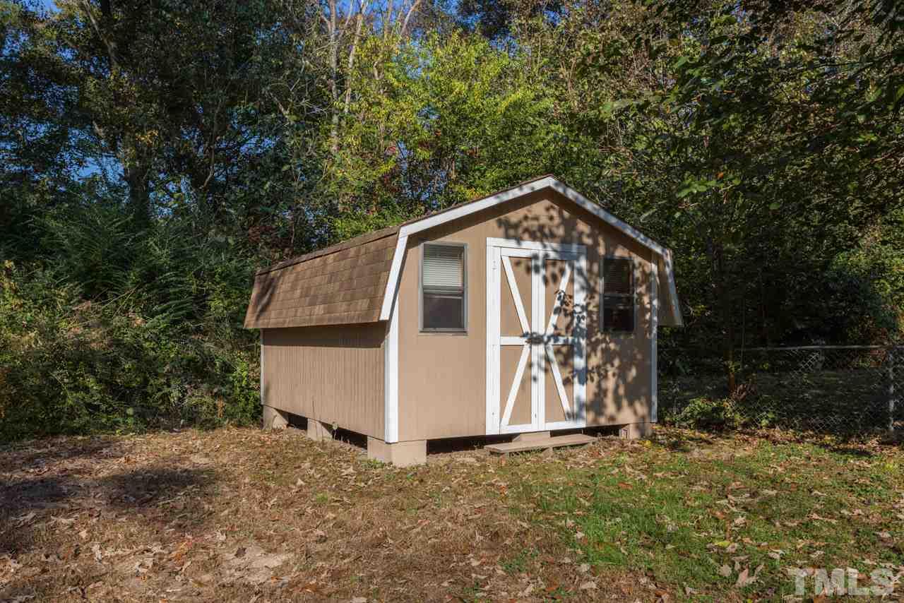 1012 Weston Street Raleigh, NC 27610 - Photo 22 of 23 a view of a small house with a small yard and large trees
