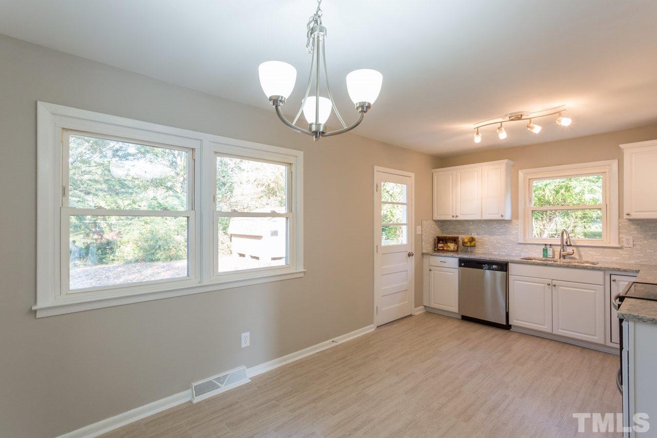 1012 Weston Street Raleigh, NC 27610 - Photo 4 of 23 a kitchen with center island wooden floor and stainless steel appliances