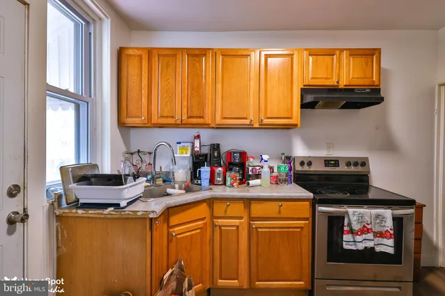 a utility room with stainless steel appliances and a wooden floor