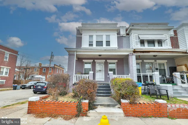a front view of a building with cars parked