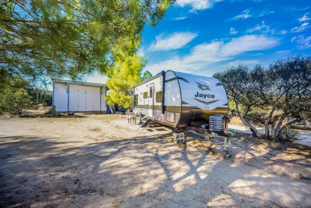 a view of a dry yard with wooden fence