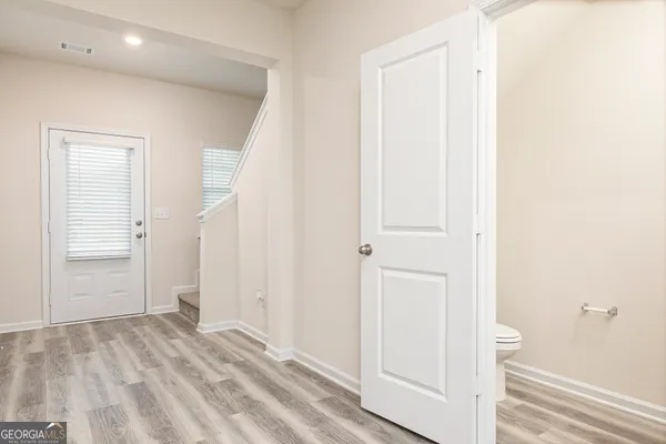 a view of a hallway with wooden floor and closet