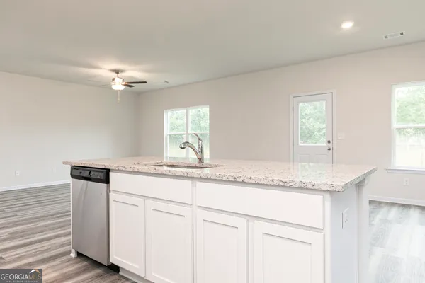 a kitchen with granite countertop cabinets stainless steel appliances a sink and a window