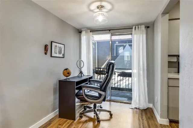 a view of a workspace with furniture and a window