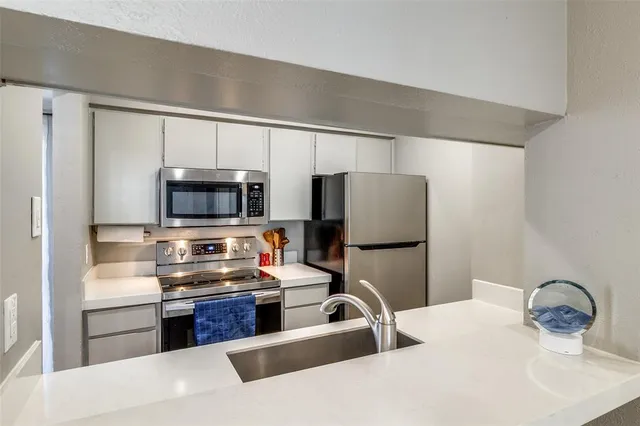 a kitchen with stainless steel appliances a refrigerator sink and microwave