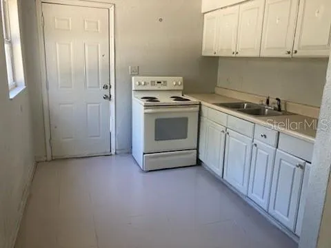 a kitchen with granite countertop white cabinets and white appliances