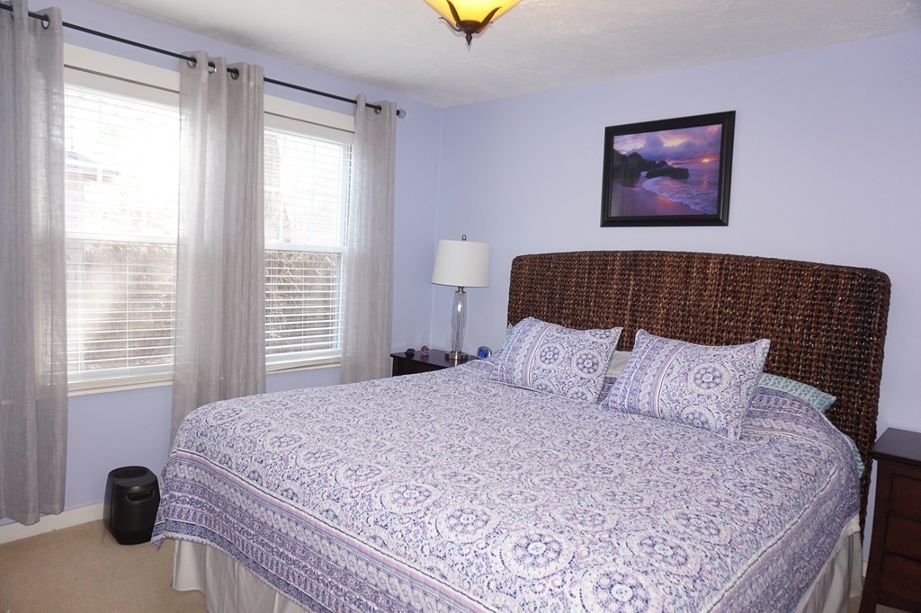 329 Mill Street Lancaster, MA 01523 - Photo 17 of 30 a bedroom with a bed and a painting on the wall