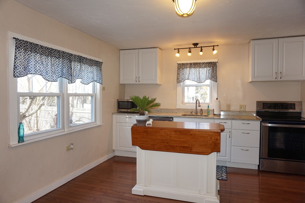 329 Mill Street Lancaster, MA 01523 - Photo 7 of 30 a kitchen with kitchen island granite countertop a stove a sink and a refrigerator