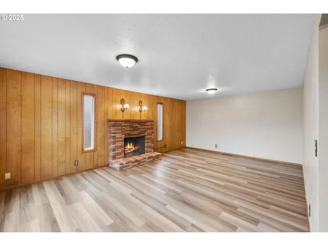 a view of an empty room with a fireplace and a window