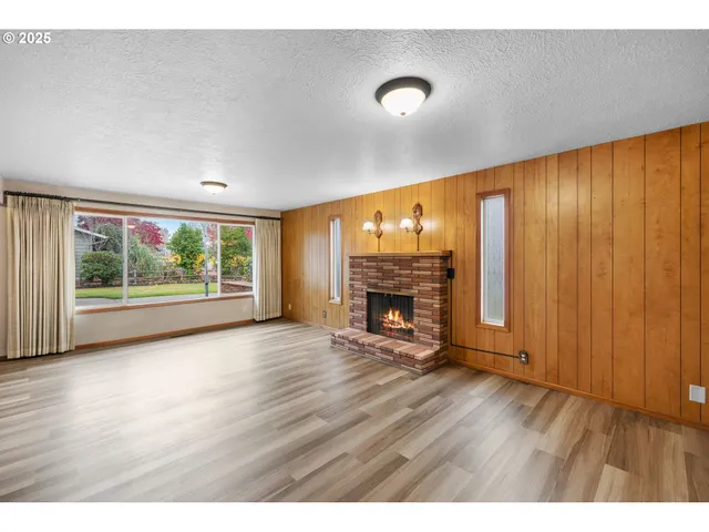 a view of an empty room with a fireplace and a window