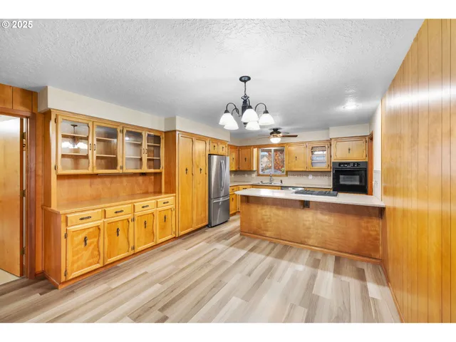 a large kitchen with granite countertop a large counter top and stainless steel appliances
