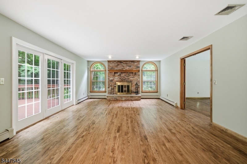 860 Glen Road Sparta, NJ 07871 - Photo 16 of 43 wooden floor fireplace and windows in an empty room