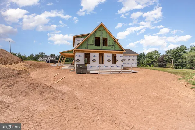a front view of house with yard and trees in the background